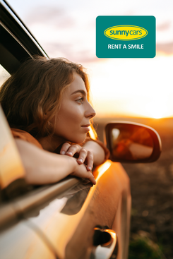 Mietwagen buchen bei Sunnycars Frau genießt entspannte Fahrt im Mietwagen mit Sunny Cars.